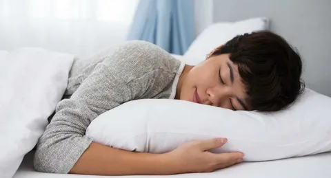 "Person sleeping peacefully in bed, illustrating the need for adequate sleep for mental health."